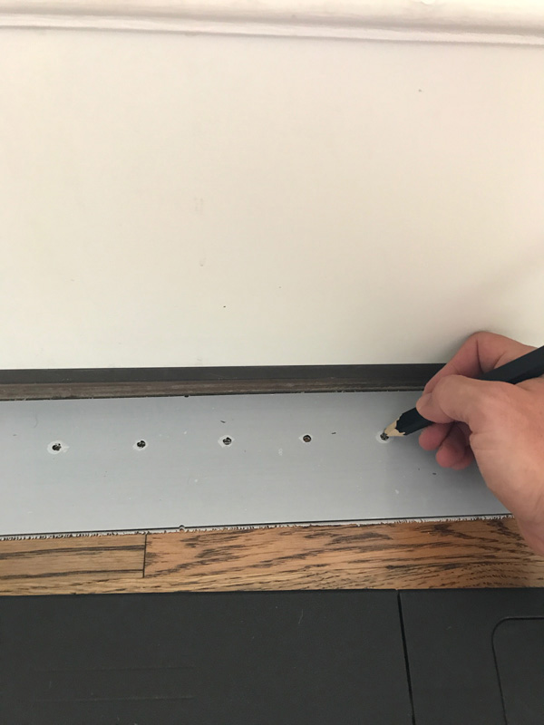 Using a pencil and your template, mark each of the six holes on the floor.